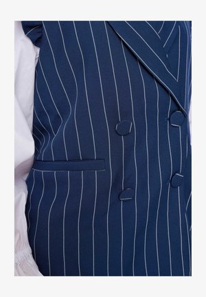 Tengerészeti csíkos mellény, amely szövetből készült, dupla gombolású dizájnnal, két gombbal és egy oldalsó zsebbel, kontrasztos fehér varrással.
