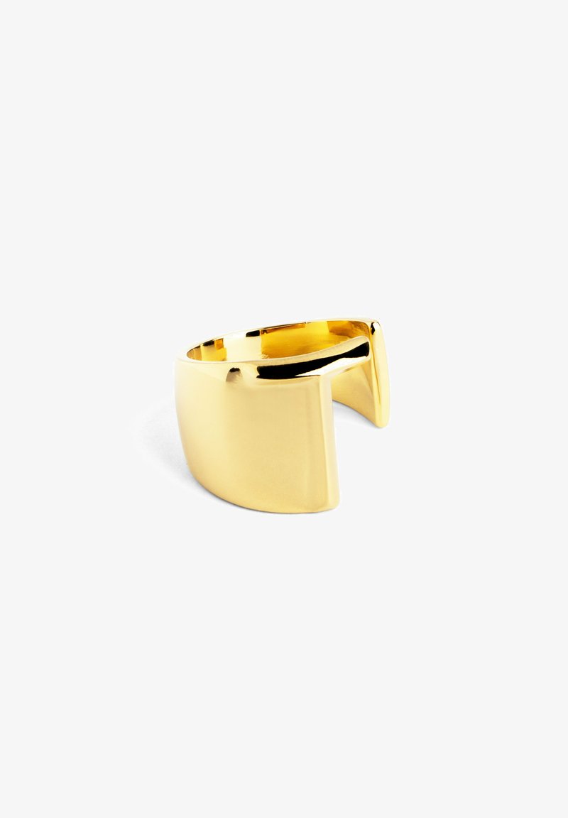 Anello in metallo color oro con un design unico a taglio geometrico. Superficie liscia e lucida e banda larga. Forma minimalista e moderna.