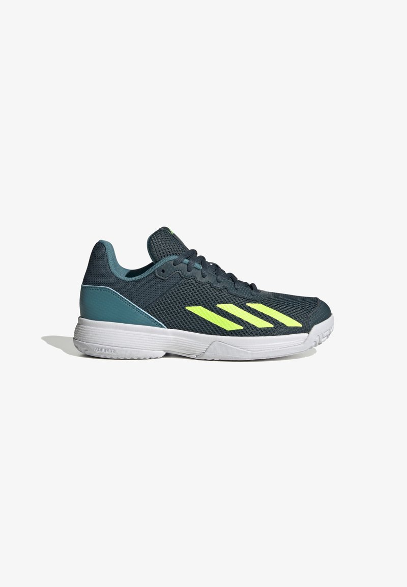 Chaussure de sport en maille vert foncé avec des accents jaunes. Présente une finition texturée, une semelle blanche et un design épuré pour des performances athlétiques.