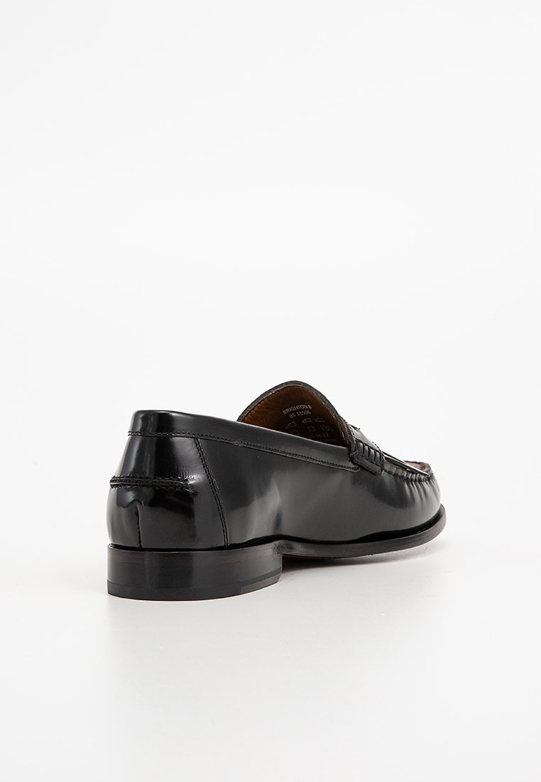 Mocassino in pelle nera con una finitura lucida, caratterizzato da cuciture decorativa e punta rotonda. La suola è piatta con un leggero tacco.