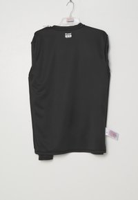 Sort ærmeløs sportstrøje hængende på en klar plastbøjle mod en hvid baggrund, synligt mærke ved kraven.