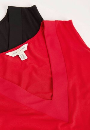 Czerwona i czarna sukienka bez rękawów z dekoltem w kształcie V, wykonana z gładkiego materiału. Widoczna metka z rozmiarem i informacjami o pielęgnacji.