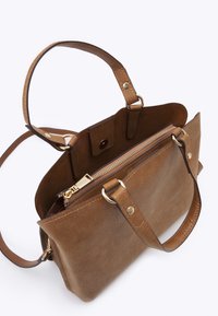 Sac à main en cuir marron avec deux poignées, une bandoulière amovible et une poche zippée dorée à l'intérieur.