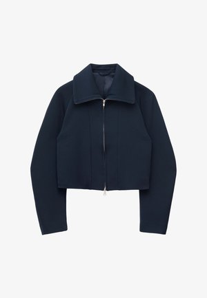 Marineblå cropped jakke med lange ærmer, bred krave og sølvfarvet lynlås foran på hvid baggrund.