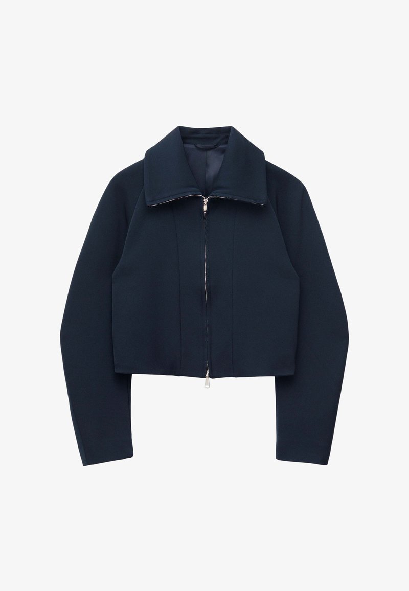 Giacca corta blu navy con maniche lunghe, collo ampio e chiusura frontale con cerniera argento su sfondo bianco.