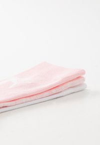 Tre par lave sokker i lavskåret stil i rosa og hvite, strikket tekstur, med hvit logo-detalj på de rosa. Enkel design, ingen mønstre.