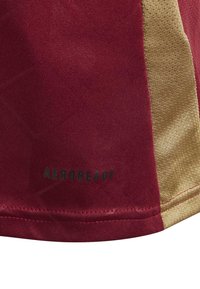 T-shirt de sport maroon avec une texture lisse, des accents dorés sur les côtés et "AEROREADY" imprimé en noir près de l'ourlet.