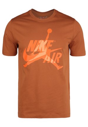 Camiseta marrón Nike Air con un gran logo naranja de Jumpman y texto estilizado "NIKE AIR" en el frente.