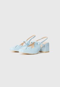 Tacchi slingback in pelle verniciata azzurro chiaro con punta arrotondata, dettaglio decorativo a fiocco e tacco a blocco. Le cinghie sono regolabili.