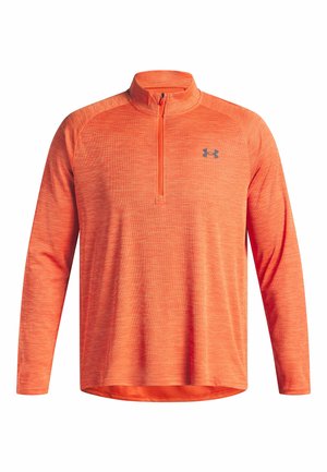 Pull-over orange à manches longues avec un col zippé mi-hauteur. Présente un motif rayé subtil et un logo noir sur la poitrine. Tissu doux et sportif.