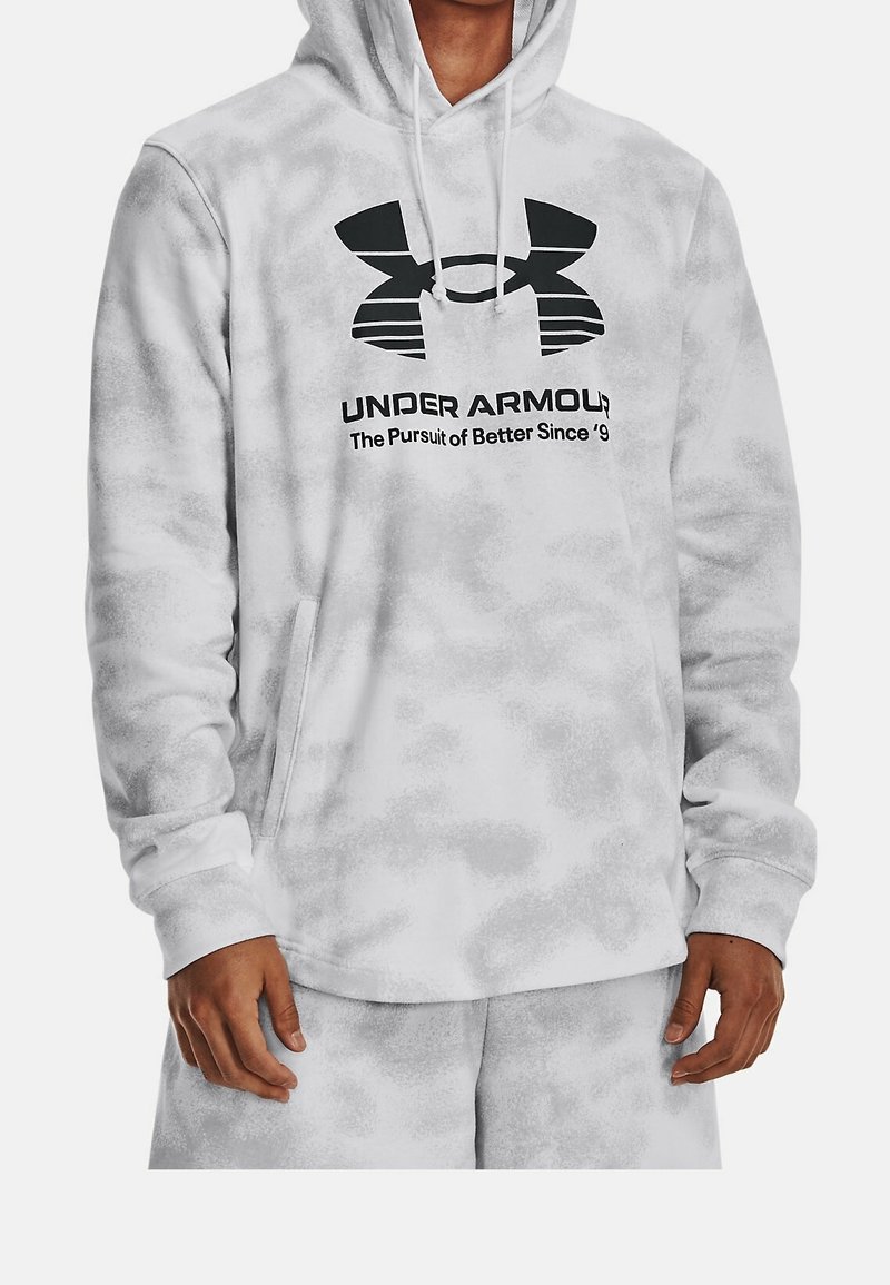 Sweat à capuche gris et blanc chiné avec logo et slogan Under Armour noirs, porté par une personne les mains détendues le long du corps.