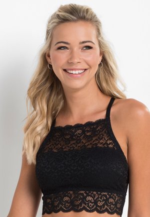Bralette en dentelle noire avec un col haut et un ourlet festonné. Le tissu présente des motifs floraux et il a de fines bretelles ajustables.