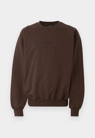 Brahna crewneck majica iz mešanice bombaža, z raglan rokavi in ribanimi manšetami, na sredini pa je v črni barvi napisan napis "TIŠINA".