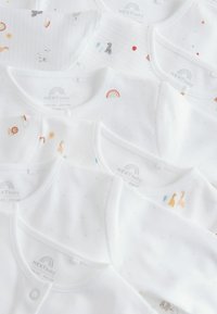 Ensemble de bodies blancs pour bébés présentant divers imprimés, y compris des animaux et des arcs-en-ciel. Tissu en coton doux, avec des fermetures à boutons et des textures délicates.