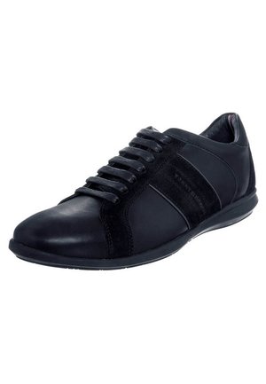 Zapatilla negra de piel de corte bajo con cordones negros y paneles laterales de ante, mostrada en un ligero ángulo sobre un fondo blanco.