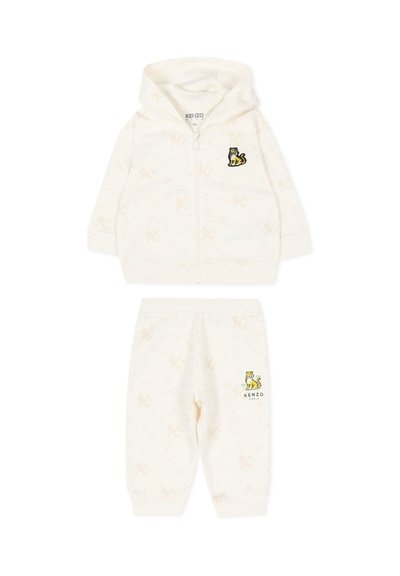 Babyset met hoodie en broek in roomkleur, met subtiele patronen en kleine gele tijgerpatches op de borst en dij, met een rits aan de voorkant van de hoodie.