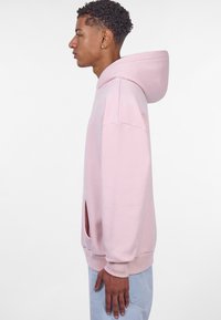Lichtroze hoodie gemaakt van een katoenmix, met een zachte textuur, capuchon en kangoeroezak. Het ontwerp bevat ribgebreide manchetten en een rechte zoom.