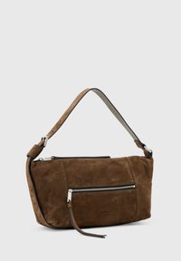 Bruine suède handtas met een gestructureerd ontwerp, voorzien van een voorzak met rits, een verstelbare schouderband en hardware accenten in zilverkleur.