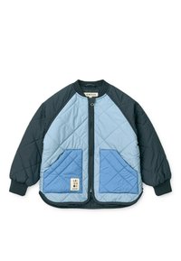 Πλεκτό μπουφάν σε σκούρο ναυτικό μπλε και ανοιχτό μπλε. Διαθέτει μανίκια ράγκλαν, φερμουάρ μπροστά και δύο μπροστινές τσέπες με μοτίβο διαμαντιού.