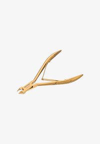 Złoty, stalowy cążek do skórek ze skośnymi, ostrymi ostrzami oraz sprężynowym mechanizmem, zapewniający precyzyjną pielęgnację paznokci.