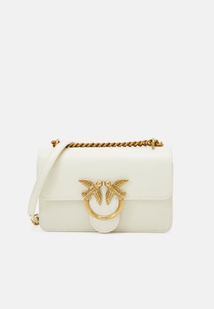 Sac à main en cuir blanc avec une bandoulière en chaîne dorée et un fermoir décoratif représentant deux oiseaux. Texture lisse avec une forme structurée et fermeture à rabat.