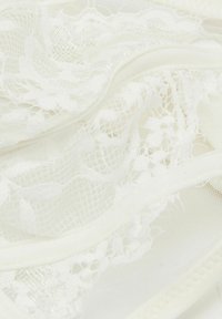 Weißer Spitzenstoff mit Blumenmustern und Netzdetails, sanft geschichtet und gefaltet.