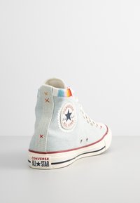 Tmavě modré vysoké tenisky Converse z plátna s duhovými proužky, logem, červeným prošíváním a bílou gumovou podrážkou.