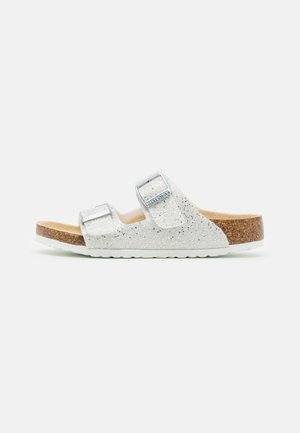 Sandalias deslizantes de purpurina plateada con dos hebillas ajustables, plantilla de corcho y suela de goma blanca. Diseño plano, estilo de punta abierta.