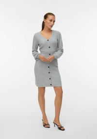 Abito cardigan grigio lavorato a maglia con scollatura a V, maniche lunghe e bottoni neri frontali, caratterizzato da una consistenza elasticizzata e orlo a ginocchio.