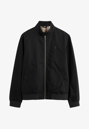 Giacca bomber nera con colletto alto, chiusura a zip, tasche frontali, polsini elastici e foderatura a quadri beige. Presenta un piccolo logo rosso.