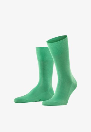 Groene enkelhandsokken gemaakt van een glad, geribbeld breimateriaal. Heeft een effen kleur en een elastische boord voor een veilige pasvorm.