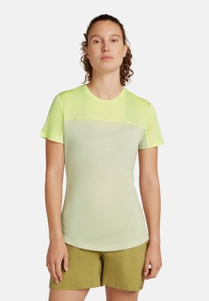 Ljusgrön t-shirt med kort ärm och en mörkgrön övre panel, rund halsringning och mjuk textur, tillsammans med ljusgröna shorts.
