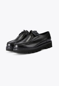 Zwarte leren schoenen met een slank ontwerp, ronde neus, vetersluiting en een uitgesproken rubberen zool met profiel. Blauwe stiksels rond de zool.