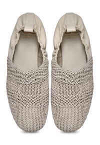 Zapatos de color beige tipo slip-on con un upper de tela de punto y un talón de cuero suave, con borde fruncido y un patrón texturado en todo el cuerpo.