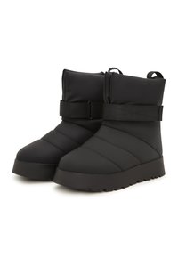 Botas negras hechas de un material acolchado con una suela gruesa. Cuentan con una correa ancha ajustable y detalles acolchados en el caña.