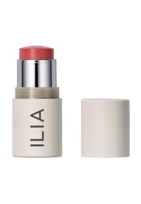 ILIA Cream Blush Stick mit einem korallenrosa oberen Teil, silbernen Akzenten und einem beigen zylindrischen Sockel. Abnehmbarer Deckel inklusive.