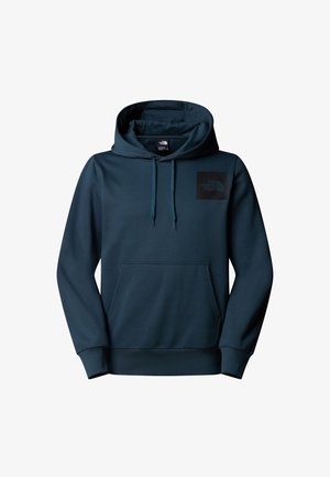 Hooded sweatshirt in dark teal with a front pocket. Features a black logo patch on the chest. Made from a soft, textured fabric.