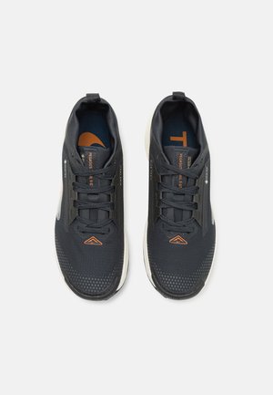 Black athletic shoes with mesh upper, textured surface, and orange accents. Designed with a cushioned sole and matching laces.