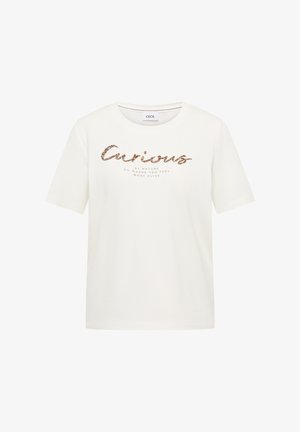 T-shirt blanc à manches courtes avec col rond, arborant en script pailleté le mot "Curious" et un texte plus petit en dessous sur le devant.