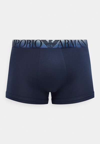Μπλε ναυτικό ανδρικό μποξεράκι με φαρδιά ελαστική ζώνη μέσης με τη μάρκα που αναγράφει "EMPORIO ARMANI" και λογότυπο αετού σε σκούρο μπλε και μαύρο χρώμα.