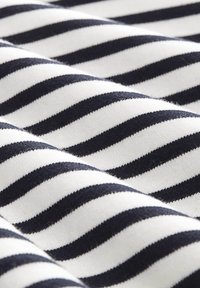 Tessuto di cotone con righe alternate blu navy e bianche, dalla texture liscia e leggermente elasticizzata.
