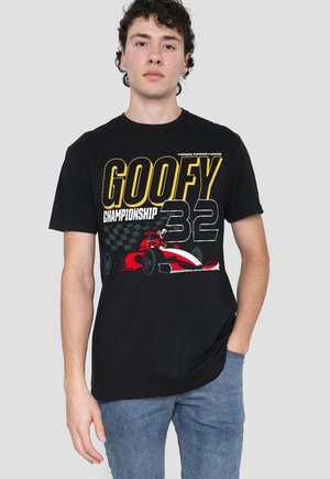 Young man wearing a black t-shirt with red racing car graphic and large yellow and white text "Goofy Championship 32" against a gray background.