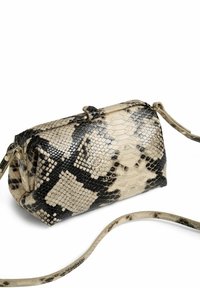 Bolso de mano con estampado de serpiente que presenta una forma estructurada, colores beige y negro, textura suave y una correa desmontable.