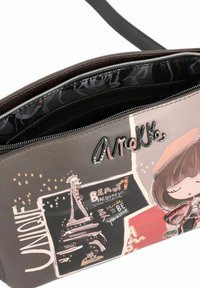 Borsa a tracolla in pelle marrone con stampe grafiche, tra cui una scena parigina, una ragazza stilizzata e del testo. Presenta una chiusura con zip e hardware decorativo.
