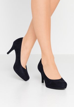 Escarpins en daim bleu marine avec un bout arrondi et un talon stiletto fin. Texture lisse et design minimaliste.