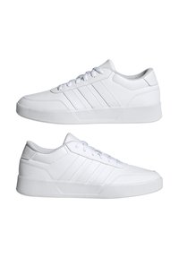 White sneakers with a textured leather upper, flat laces, three side stripes, and a sturdy rubber sole; minimalist design and smooth finish.