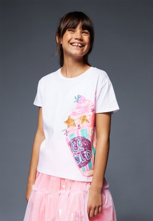 T-shirt en coton blanc avec un design de cornet de glace coloré et pailleté, avec des accents roses et bleus ; manches courtes et coupe décontractée.