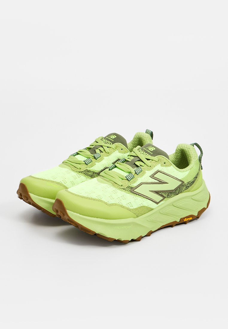 Par de zapatillas de running New Balance verde claro con suelas de goma y cierre de cordones sobre fondo blanco.