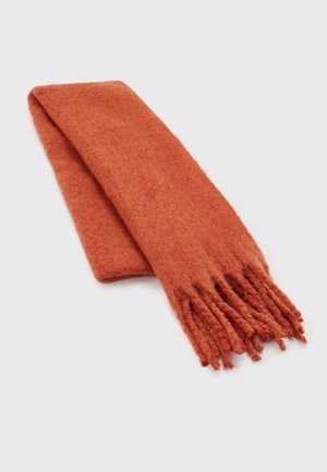 Écharpe en laine orange brûlée douce et pliée, avec des extrémités frangées, posée à plat sur une surface claire.