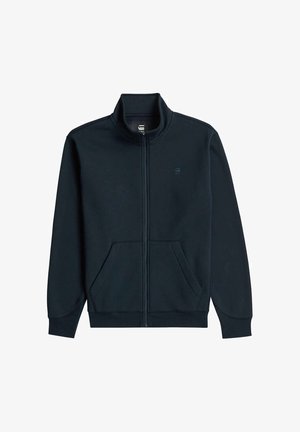 Giacca nera con zip, colletto alto, tasche anteriori e polsini e bordo a costine, mostrata su sfondo bianco.